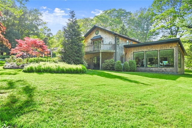 back of house featuring a balcony and a lawn