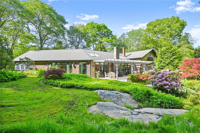 rear view of property featuring a yard and a patio area