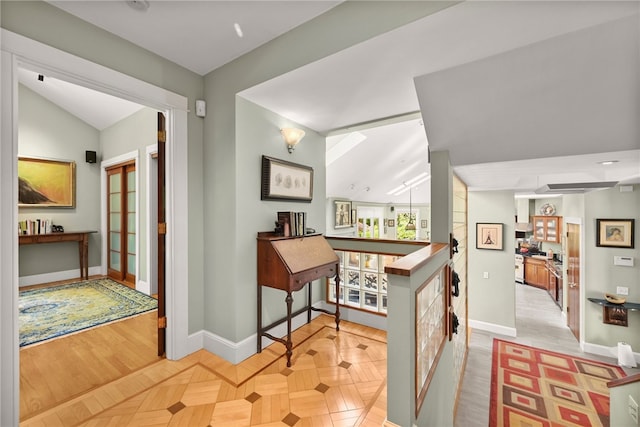 hallway featuring lofted ceiling, plenty of natural light, and light parquet flooring