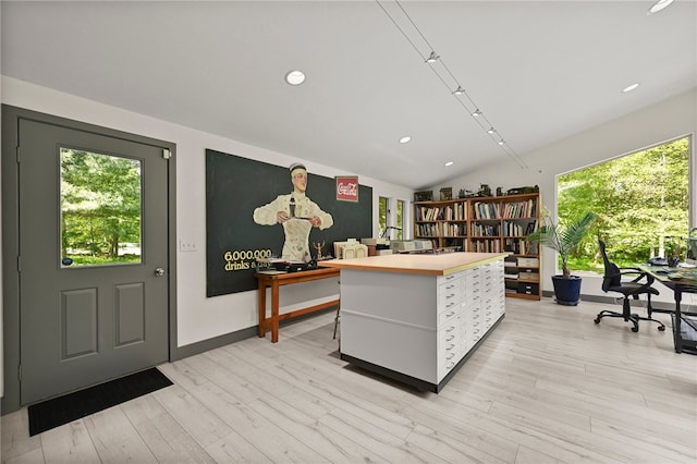 office space with lofted ceiling and light wood-type flooring