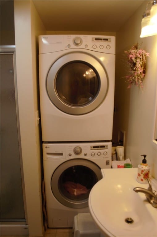 laundry room featuring sink and stacked washing maching and dryer