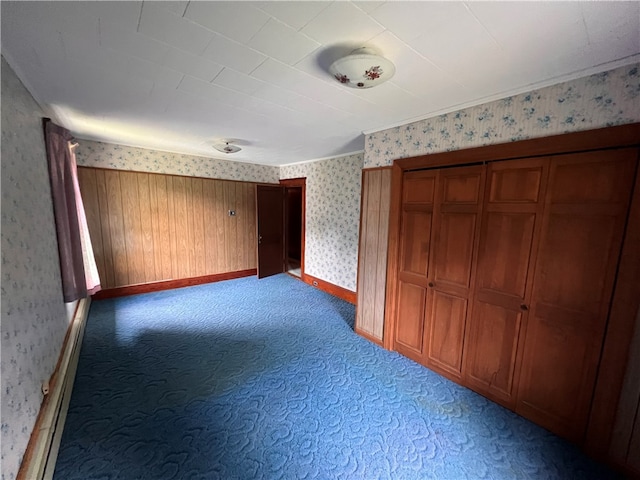 unfurnished bedroom with wood walls and carpet flooring