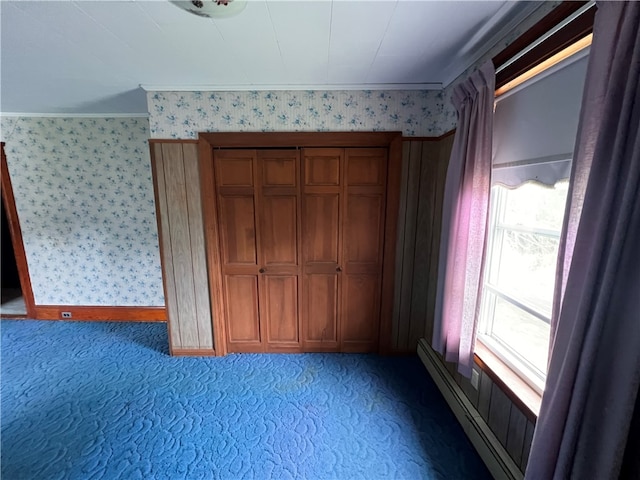 unfurnished bedroom with baseboard heating, carpet, and crown molding