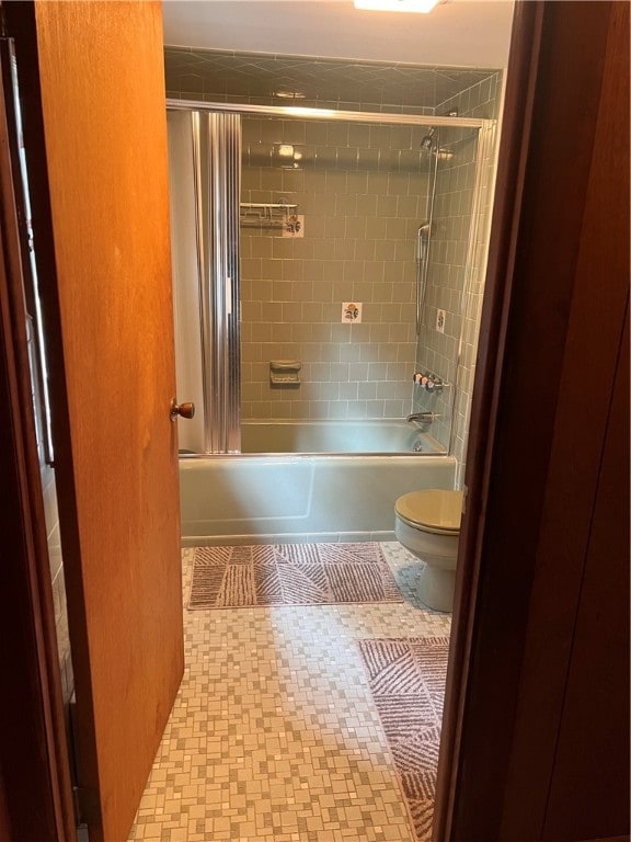 bathroom featuring tiled shower / bath combo and toilet