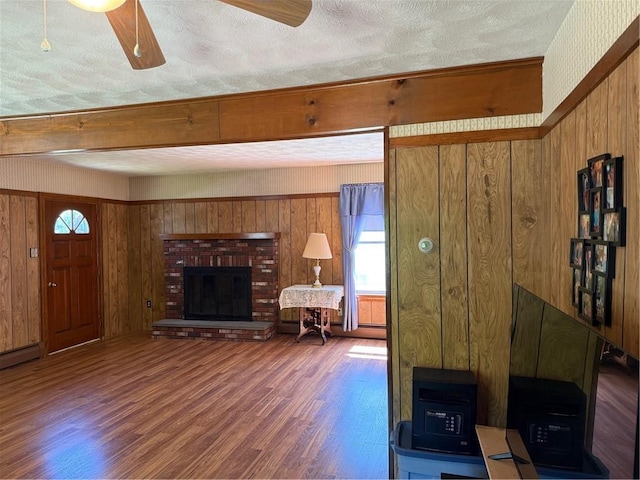 505 Central St, Burrillville, RI 02839 - living area featuring wood finished floors, healthy amount of natural light, wooden walls, and a brick fireplace