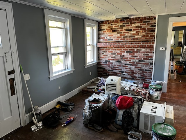 miscellaneous room featuring brick wall and hardwood / wood-style floors