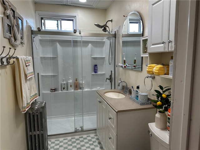 bathroom featuring a healthy amount of sunlight, an enclosed shower, radiator, and vanity