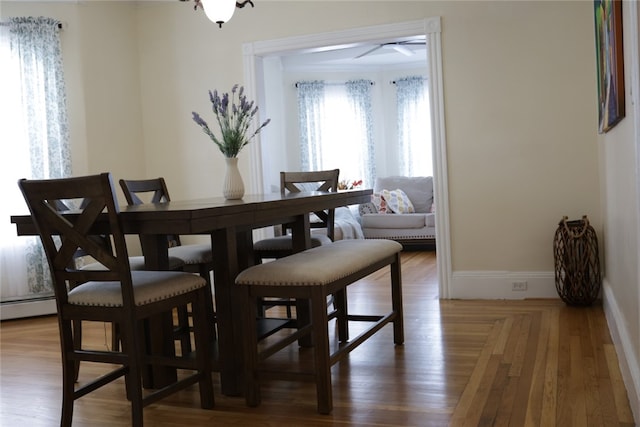 dining space with baseboard heating and hardwood / wood-style floors