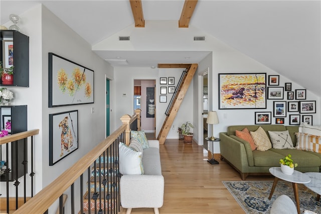 living room featuring light hardwood / wood-style floors and lofted ceiling with beams