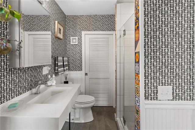 bathroom featuring a shower with door, toilet, and vanity