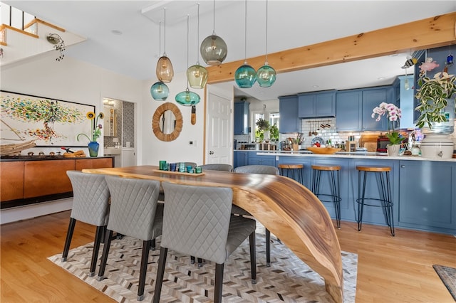 dining room featuring light hardwood / wood-style flooring and beam ceiling