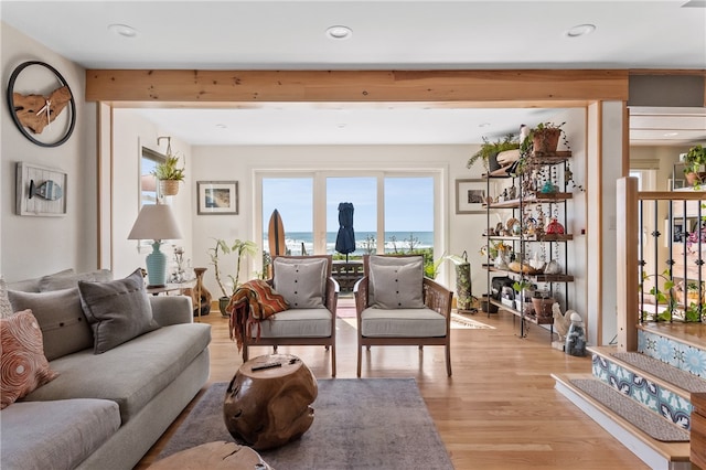 living room featuring light hardwood / wood-style floors and a water view