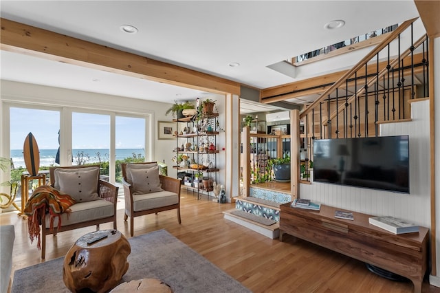 living room featuring hardwood / wood-style flooring and a water view