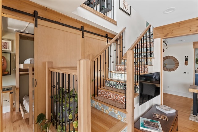 stairs featuring wood-type flooring and a barn door