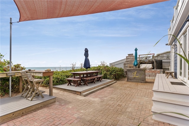 view of patio with a deck with water view