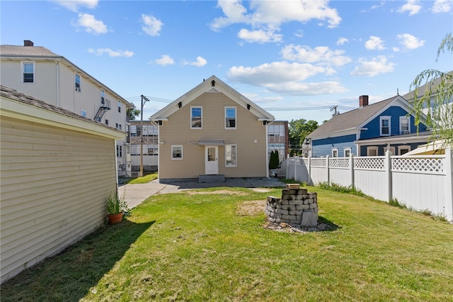 back of property with a yard and a patio area