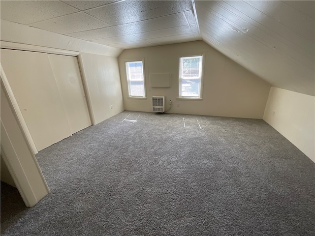 additional living space featuring carpet flooring and vaulted ceiling