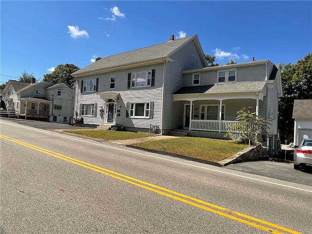 view of front of property with a front yard and covered porch