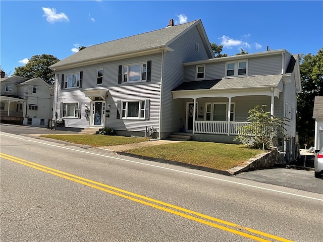 view of front facade with a front yard and a porch