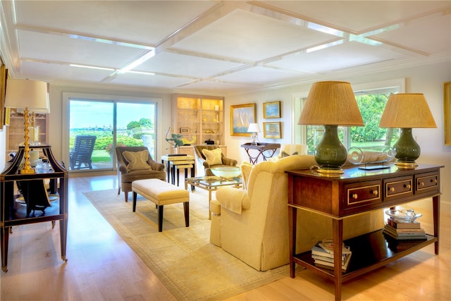 living room with light wood-type flooring, crown molding, and coffered ceiling