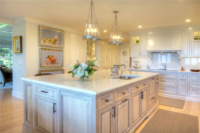 kitchen with light hardwood / wood-style flooring, an island with sink, white cabinetry, and sink