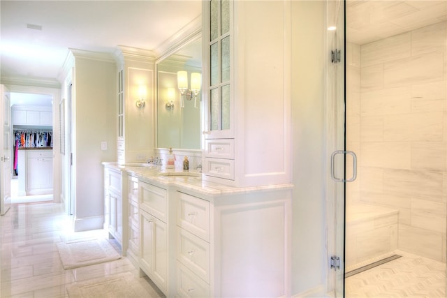 bathroom featuring ornamental molding, vanity, and a shower with shower door