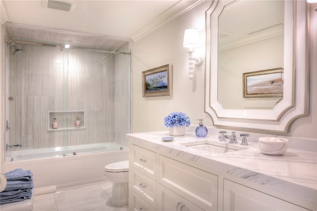 full bathroom featuring tile patterned flooring, tiled shower / bath, crown molding, toilet, and vanity