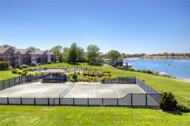 surrounding community featuring tennis court, a yard, and a water view