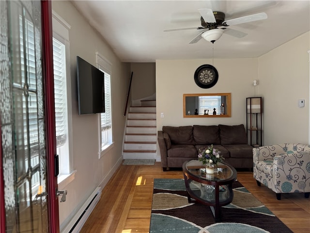 living room featuring baseboard heating, hardwood / wood-style flooring, and ceiling fan