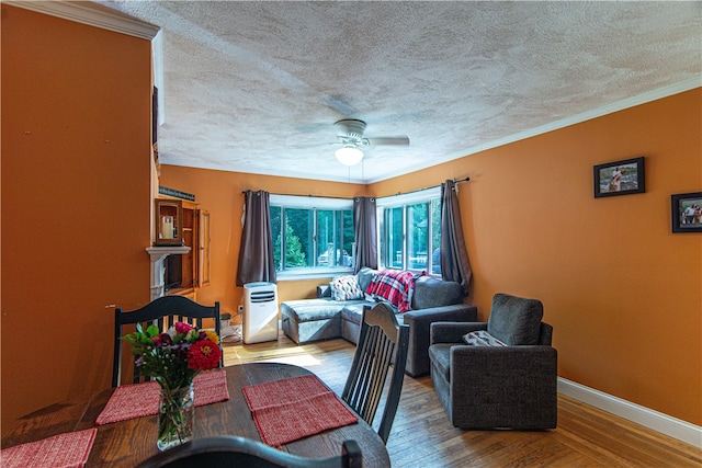 living room featuring a textured ceiling, crown molding, ceiling fan, and light wood-type flooring