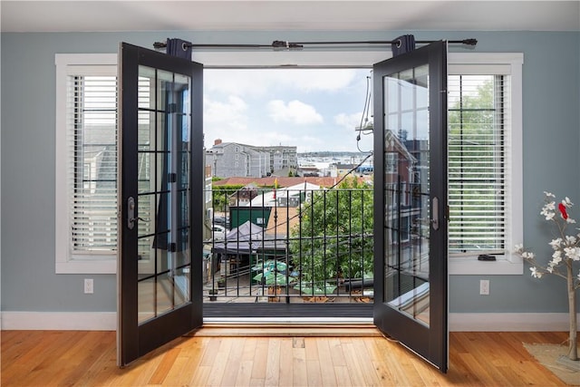 entryway with french doors, wood finished floors, and baseboards