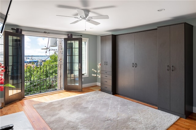 unfurnished bedroom with multiple windows, ceiling fan, and light hardwood / wood-style flooring