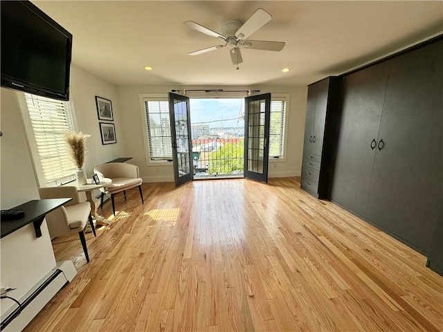 interior space featuring light wood finished floors, recessed lighting, baseboard heating, access to outside, and baseboards