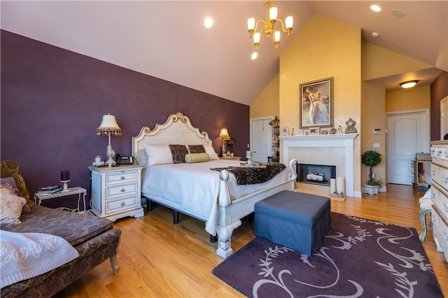 bedroom with a notable chandelier, light hardwood / wood-style flooring, and high vaulted ceiling