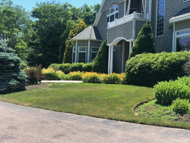 view of side of property with a balcony and a yard