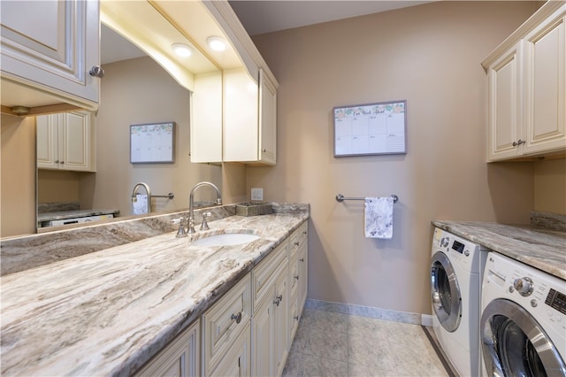 laundry room featuring cabinets, light tile patterned floors, washer and dryer, and sink