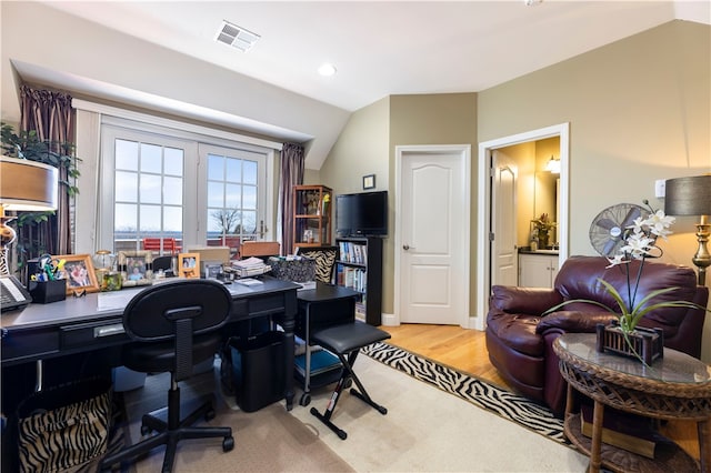 office space with light wood-type flooring and vaulted ceiling