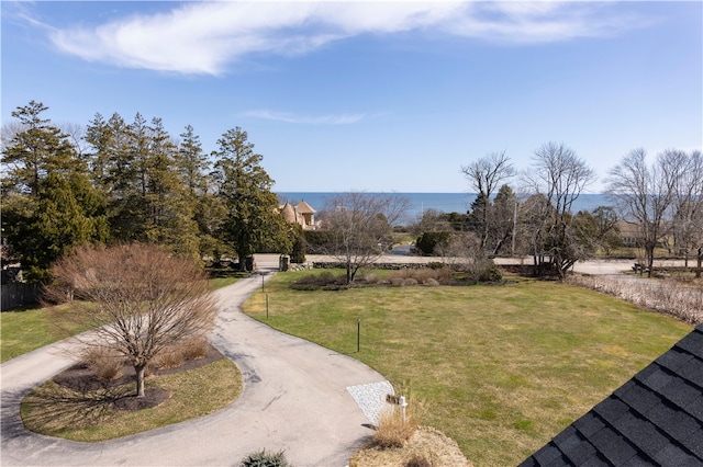 view of property's community with a water view and a yard