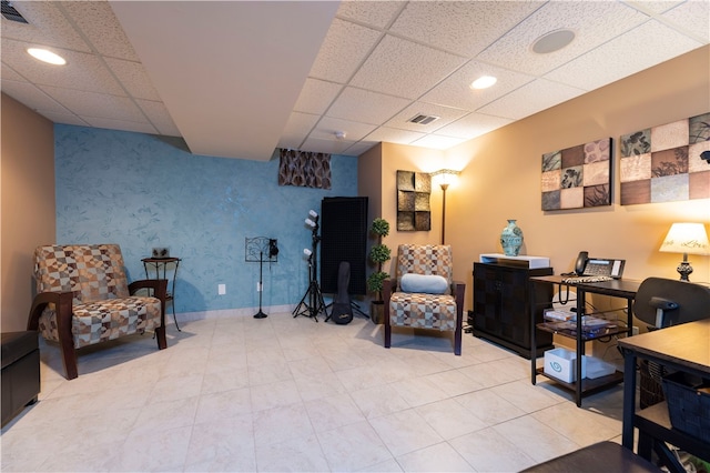 living area featuring a drop ceiling