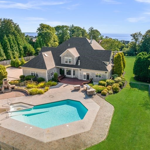 view of pool with a patio, a water view, and a yard