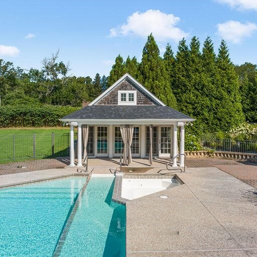 view of swimming pool featuring a patio and an outbuilding