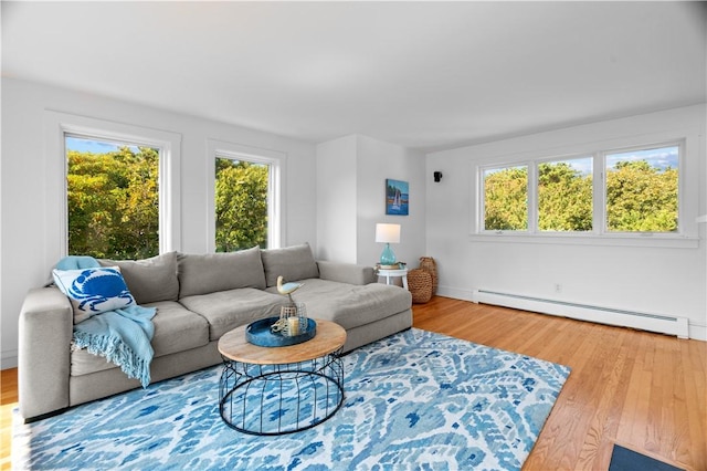 living room with a healthy amount of sunlight, a baseboard radiator, and wood-type flooring