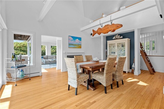 dining room with high vaulted ceiling, beam ceiling, and light wood-type flooring