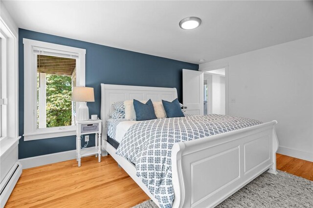 bedroom with hardwood / wood-style flooring and a baseboard radiator