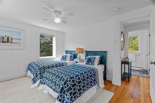 bedroom with wood-type flooring, a baseboard radiator, and ceiling fan