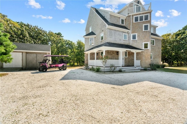 view of front of house featuring a porch and a storage shed