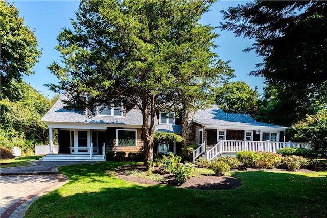 view of front of house with a porch, a deck, and a front lawn