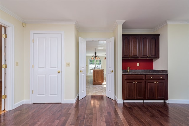 interior space featuring ornamental molding, dark brown cabinets, and dark wood-type flooring