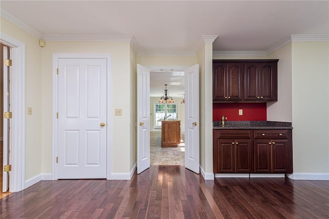 bar featuring baseboards, dark wood finished floors, and ornamental molding