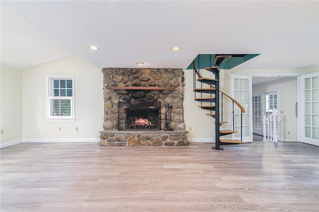 unfurnished living room featuring wood finished floors, a fireplace, baseboards, stairway, and recessed lighting
